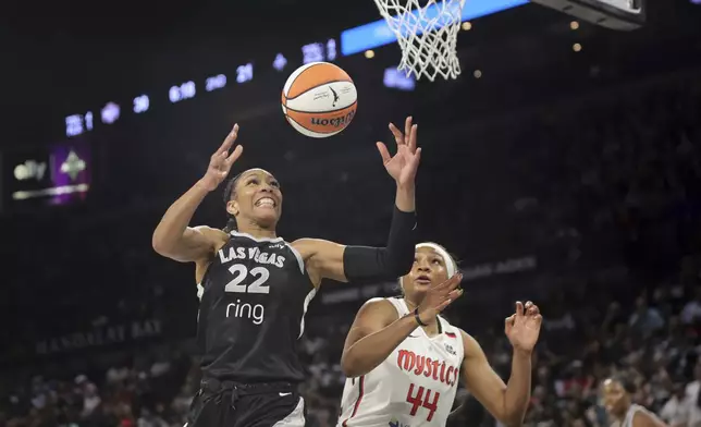 Las Vegas Aces center A'ja Wilson (22) and Washington Mystics forward Kiki Iriafen (44) go after a rebound during the first half of a WNBA basketball game Friday, May 23, 2025, in Las Vegas. (Steve Marcus/Las Vegas Sun via AP)