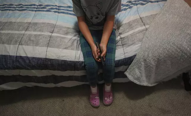 FILE - A 9-year-old girl with Temporary Protected Status, or TPS, who was born in Venezuela, but who fluently speaks only English and is in the gifted program at her school, watches TV in her family's apartment, April 5, 2025, in Doral, Fla. (AP Photo/Rebecca Blackwell, File)