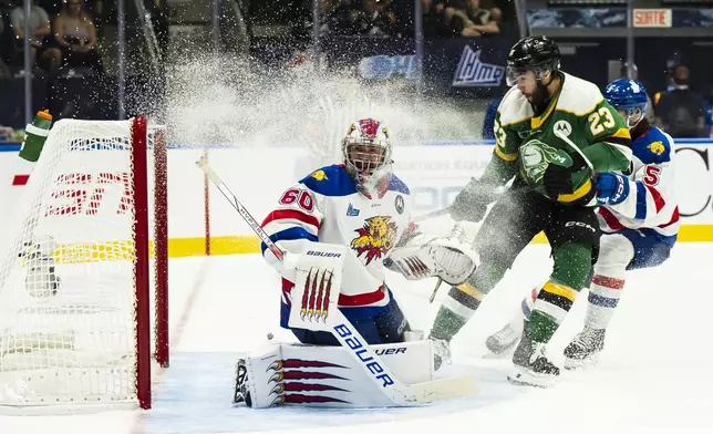 Moncton Wildcats goaltender Mathis Rousseau (60) makes a save against London Knights' Sam O'Reilly (23) during first-period semifinal Memorial Cup hockey action in Rimouski, Quebec, Friday, May 30, 2025. (Christopher Katsarov/The Canadian Press via AP)