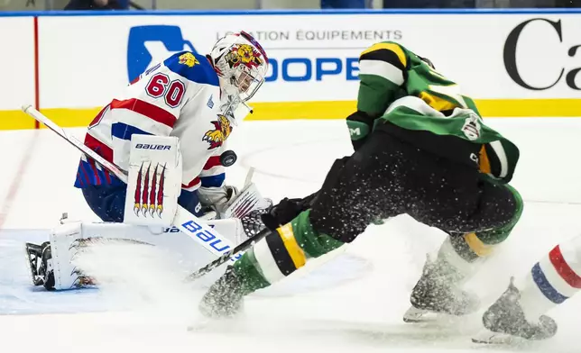 Moncton Wildcats goaltender Mathis Rousseau (60) makes a save against London Knights' Sam O'Reilly, right, during first-period semifinal Memorial Cup hockey action in Rimouski, Quebec, Friday, May 30, 2025. (Christopher Katsarov/The Canadian Press via AP)
