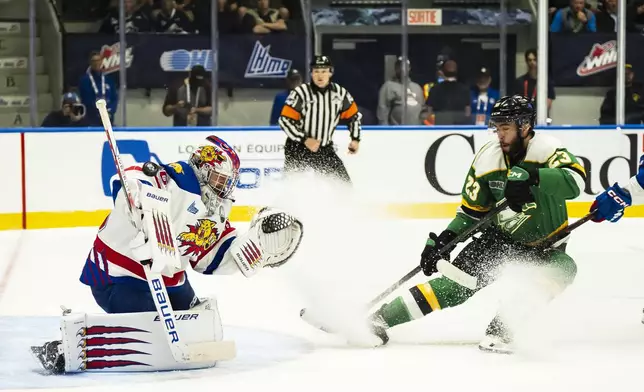 Moncton Wildcats goaltender Mathis Rousseau, left, makes a save against London Knights' Sam O'Reilly (23) during first-period semifinal Memorial Cup hockey action in Rimouski, Quebec, Friday, May 30, 2025. (Christopher Katsarov/The Canadian Press via AP)