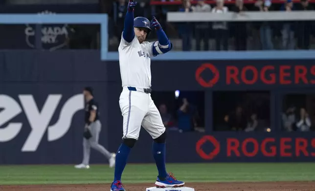 Toronto Blue Jays right fielder George Springer (4) gestures to the dugout after hitting a double against the Cleveland Guardians during the first inning of a baseball game in Toronto, Saturday, May 3, 2025. (Jon Blacker/The Canadian Press via AP)