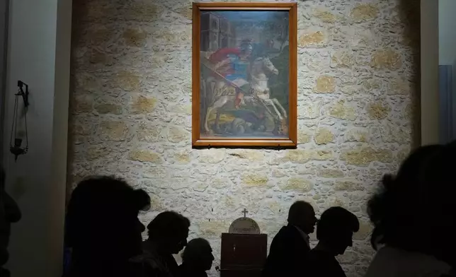 A painting of St. George hangs on the wall of St. George Church as the faithful attend a service, in the Maronite village of Kormakitis in the breakaway north of the ethnically divided Cyprus on Wednesday, April 23, 2025. (AP Photo/Petros Karadjias)