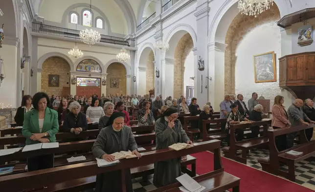 Maronite Catholic faithful attend a service on the Feast Day of St. George in St. George Church in the Maronite village of Kormakitis in the breakaway north of the ethnically divided Cyprus on Wednesday, April 23, 2025. (AP Photo/Petros Karadjias)