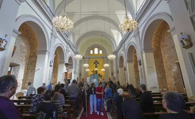 Faithful follow a traditional procession on the Feast Day of St. George in St. George Church in the Maronite village of Kormakitis in the breakaway north of the ethnically divided Cyprus on Wednesday, April 23, 2025. (AP Photo/Petros Karadjias)