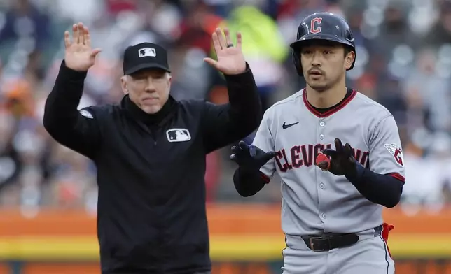 Cleveland Guardians' Steven Kwan, right, celebrates after his double against the Detroit Tigers in front of umpire Lance Barksdale, left, during the first inning of a baseball game Friday, May 23, 2025, in Detroit. (AP Photo/Duane Burleson)