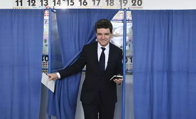 Presidential candidate Nicusor Dan exits a voting cabin before casting his vote in the second round of the country's presidential election redo in Fagaras, Romania, Sunday, May 18, 2025. (AP Photo/Eduard Vinatoru)