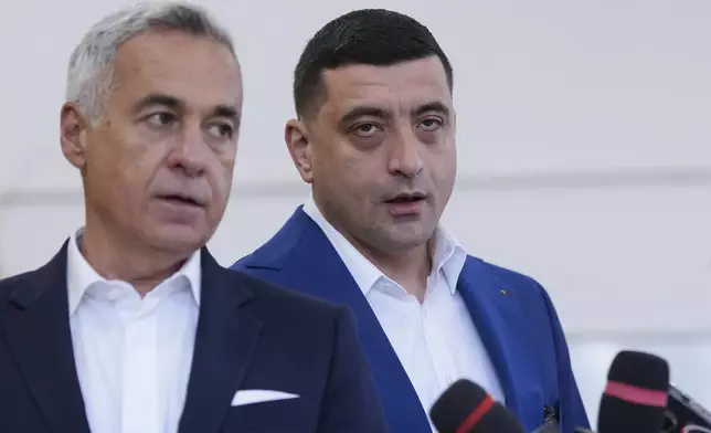 Presidential candidate George Simion, right, and Calin Georgescu, winner of the first round of last year's annulled election, speak to media after casting their votes in the second round of the country's presidential election redo in Mogosoaia, Romania, Sunday, May 18, 2025. (AP Photo/Andreea Alexandru)