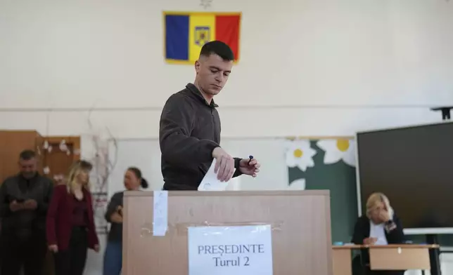 A man casts his vote in the second round of the country's presidential election redo in Mogosoaia, Romania, Sunday, May 18, 2025. (AP Photo/Andreea Alexandru)