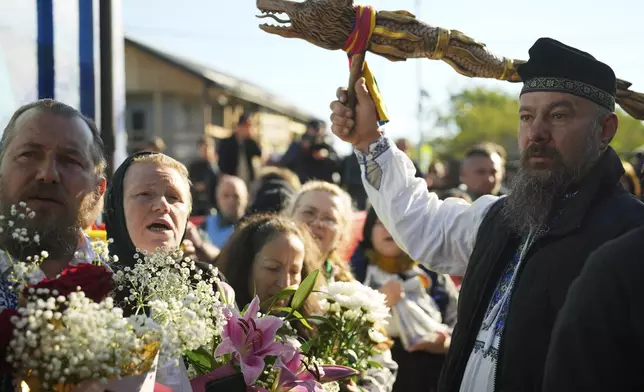 Supporters of Presidential candidate George Simion and Calin Georgescu, winner of the first round of last year's annulled election, gather in front of a polling station in the second round of the country's presidential election redo in Mogosoaia, Romania, Sunday, May 18, 2025. (AP Photo/Vadim Ghirda)