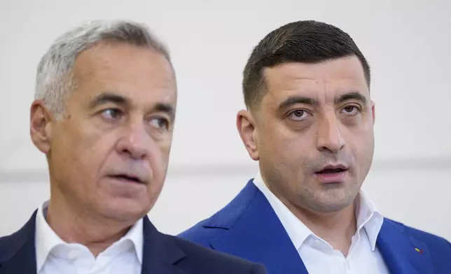 Presidential candidate George Simion, right, and Calin Georgescu, winner of the first round of last year's annulled election, speak to the media after casting their votes in the second round of the country's presidential election redo in Mogosoaia, Romania, Sunday, May 18, 2025. (AP Photo/Andreea Alexandru)