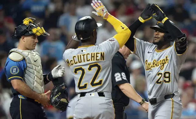 Pittsburgh Pirates' Alexander Canario, right, celebrates after his three-run home run with Andrew McCutchen, center, as Philadelphia Phillies catcher J.T. Realmuto, left, looks on the sixth inning of a baseball game, Friday, May 16, 2025, in Philadelphia. (AP Photo/Chris Szagola)