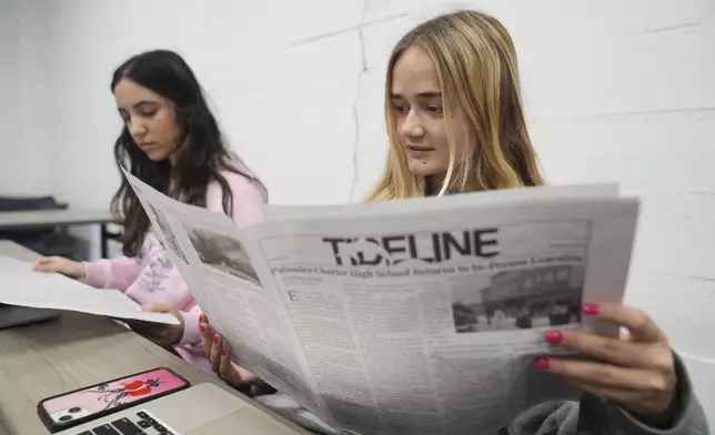 Staff members of Tideline, Palisades High School's newspaper, Sophia Masserat, left, and Eve Keller read a copy of the publication, freshly delivered from Philadelphia, Wednesday, May 14, 2025, in Santa Monica, Calif. (AP Photo/Marcio Jose Sanchez)