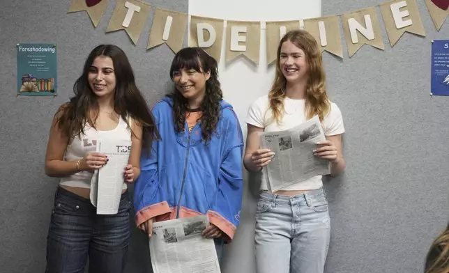 Members of of the Palisades High School newspaper staff, from left to right, Cloé Nourparvar, Gigi Appelbaum, and Kate Swain, hold a copy of the school's publication, which was printed in Philadelphia, Wednesday, May 14, 2025, in Santa Monica, Calif. (AP Photo/Marcio Jose Sanchez)