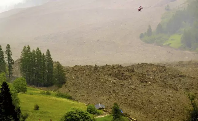 A large avalanche with a mixture of ice, rock, snow and water reach the valley floor is pictured in Wiler after the Birch glacier collapsing above Blatten, Switzerland, Wednesday, May 28, 2025. (Jean-Christophe Bott/Keystone via AP)