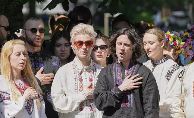 Eurovision band Ziferblat of Ukraine sings their national anthem with Ukrainian people during a family meeting in a park in Basel as part of the 69th Eurovision Song Contest week, in Basel, Switzerland, Thursday, May 15, 2025. (AP Photo/Martin Meissner)