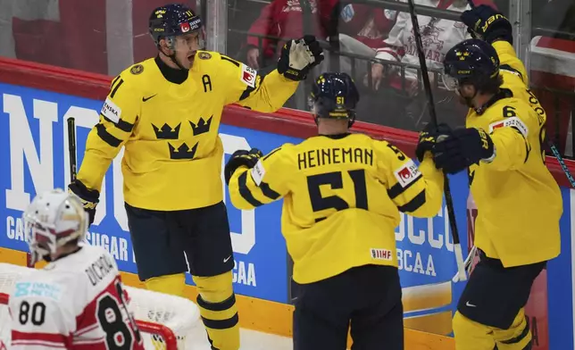 Swedish players celebrate after a goal during the bronze medal match between Denmark and Sweden at the ice hockey world championships in Stockholm, Sweden, Sunday, May 25, 2025. (AP Photo/Petr David Josek)