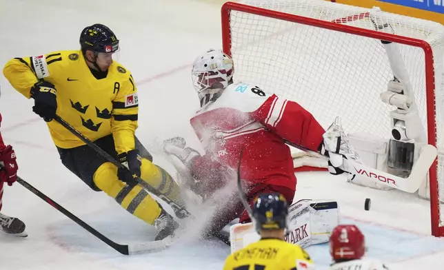 Sweden's Mikael Backlund in action in front of Denmark's Frederik Dichow during the bronze medal match between Denmark and Sweden at the ice hockey world championships in Stockholm, Sweden, Sunday, May 25, 2025. (AP Photo/Petr David Josek)