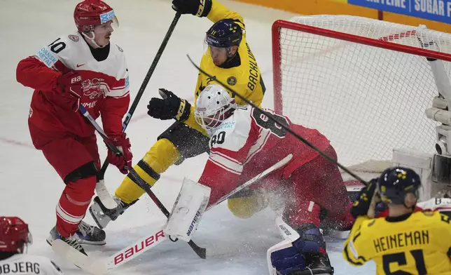 Sweden's Mikael Backlund in action in front of Denmark's goalkeeper Frederik Dichow during the bronze medal match between Denmark and Sweden at the ice hockey world championships in Stockholm, Sweden, Sunday, May 25, 2025. (AP Photo/Petr David Josek)