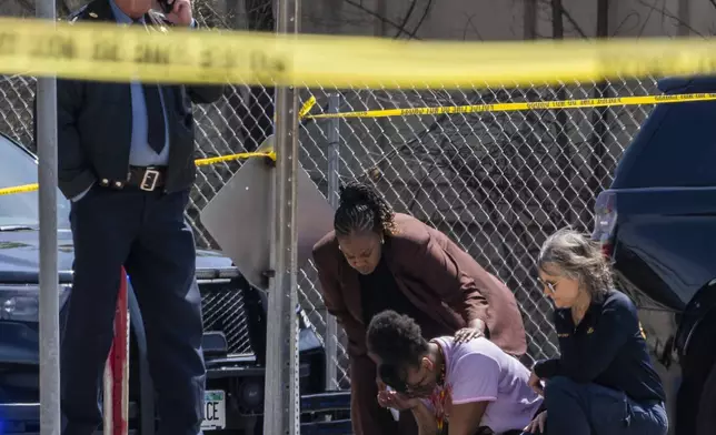 A police officer works on the scene as a bystander is shook up by the homicide in front of 2107 Cedar Ave S in Minneapolis, Minn., on Wednesday, April 30, 2025. (Richard Tsong-Taatarii/Star Tribune via AP)