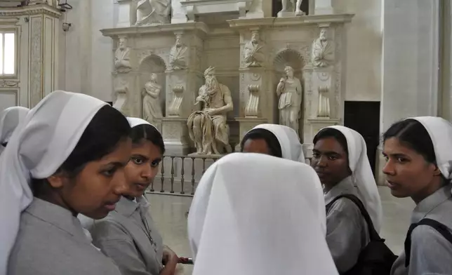 FILE - Nuns talk in front of Italian Renaissance artist Michelangelo Buonarroti's Moses statue, part of a funerary monument he designed for Pope Julius II inside San Pietro in Vincoli Basilica in Rome, July 2, 2013. (AP Photo/Gregorio Borgia, File)