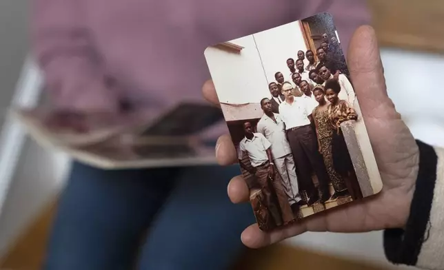 Anna Eisenberg, left, and her mother Cathy Votaw, 69, look at photographs of Votaw's father, Albert Votaw, during his service with USAID in West Africa, Thursday, Feb. 27, 2025, at their home in Washington. (AP Photo/Jacquelyn Martin)