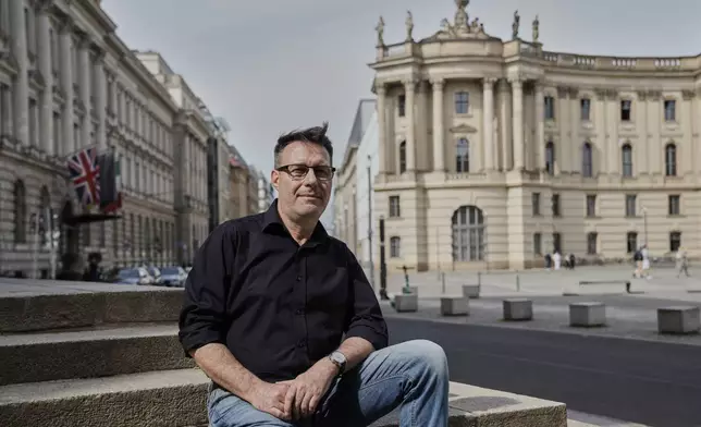 Carlo Caniglia, 60, an Italian Catholic, sits for a portrait in front of St. Hedwig's Cathedral in Berlin, Germany, Friday, May 2, 2025. (AP Photo/Ebrahim Noroozi)