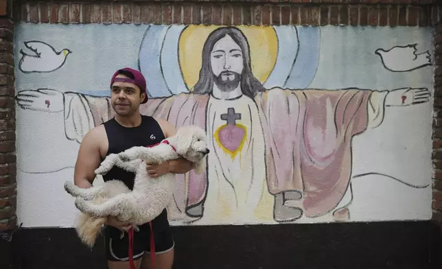 Alicler Medina, 35, holds his dog, Oru, in Buenos Aires, Argentina, on Thursday, May 1, 2025. (AP Photo/Natacha Pisarenko)