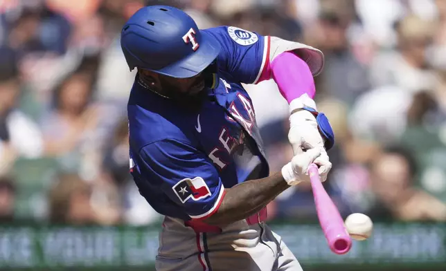 Texas Rangers' Adolis García hits a pitch that Detroit Tigers third baseman Jace Jung had an error on in the seventh inning during a baseball game, Sunday, May 11, 2025, in Detroit. (AP Photo/Paul Sancya)