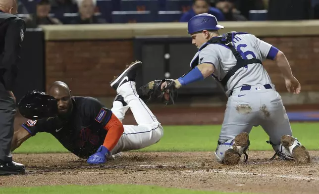 New York Mets' Starling Marte, second from right, scores against Los Angeles Dodgers catcher Will Smith, right, on a sacrifice fly hit by Pete Alonso during the fourth inning of a baseball game Friday, May 23, 2025, in New York. (AP Photo/Pamela Smith)