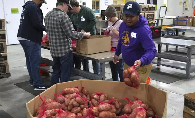 Volunteers pack produce at the Alameda County Community Food Bank in Alameda, Calif., on Friday, April 25, 2025. (AP Photo/Terry Chea)