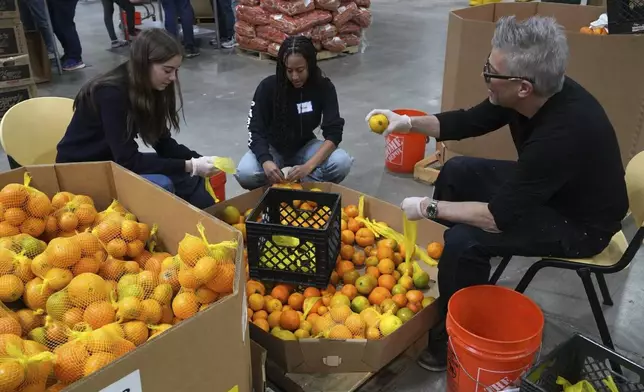 Volunteers pack produce at the Alameda County Community Food Bank in Alameda, Calif., on Friday, April 25, 2025. (AP Photo/Terry Chea)