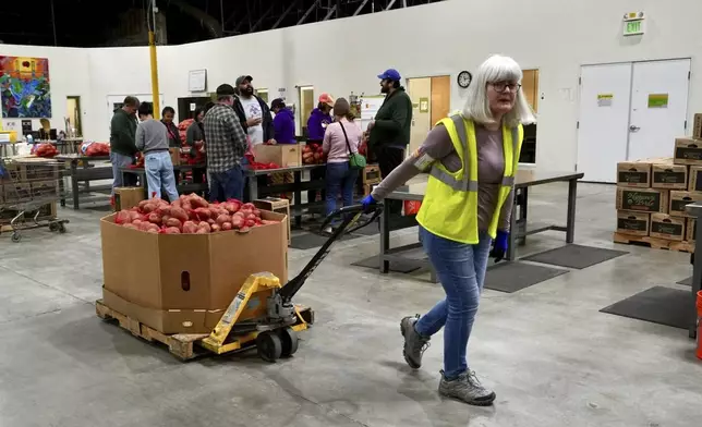 A volunteer pulls box of produce at the Alameda County Community Food Bank in Alameda, Calif., on Friday, April 25, 2025. (AP Photo/Terry Chea)