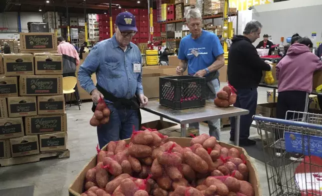 Volunteers pack produce at the Alameda County Community Food Bank in Alameda, Calif., on Friday, April 25, 2025. (AP Photo/Terry Chea)