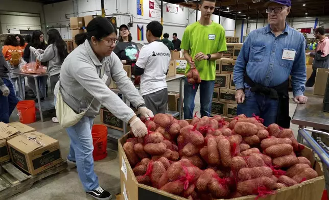 Volunteers pack produce at the Alameda County Community Food Bank in Alameda, Calif., on Friday, April 25, 2025. (AP Photo/Terry Chea)
