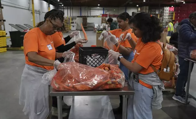 Volunteers pack produce at the Alameda County Community Food Bank in Alameda, Calif., on Friday, April 25, 2025. (AP Photo/Terry Chea)
