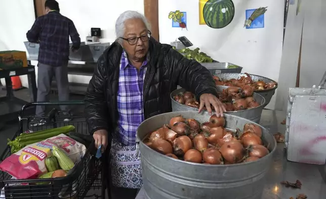 Alameda resident Beatriz Cortez picks up groceries at the Alameda Food Bank on Friday, April 25, 2025. (AP Photo/Terry Chea)