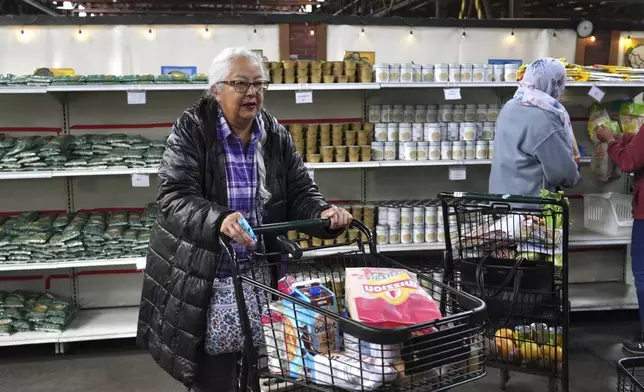 Alameda resident Beatriz Cortez picks up groceries at the Alameda Food Bank on Friday, April 25, 2025. (AP Photo/Terry Chea)