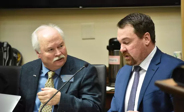 Montana Democratic Minority Leader Sen. Pat Flowers, left, speaks with Republican Sen. Josh Kassmier during a committee meeting at the state Capitol, April 16, 2025, in Helena, Mont. (AP Photo/Matthew Brown)