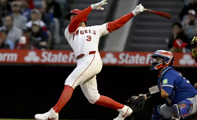 Los Angeles Angels' Taylor Ward (3) hits a two-run home run next to Toronto Blue Jays catcher Alejandro Kirk to score Zach Neto during the first inning of a baseball game in Anaheim, Calif., Tuesday, May 6, 2025. (AP Photo/Alex Gallardo)