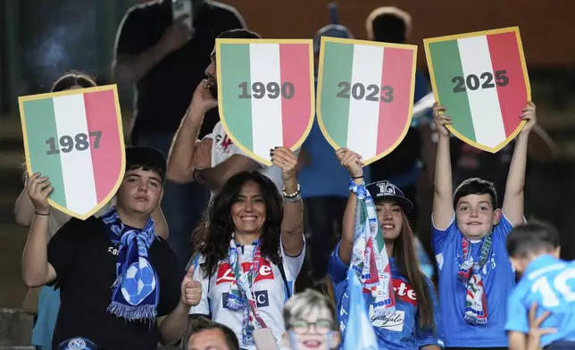 Napoli fans hold three 'scudetto', referring to the Serie A titles won in 1987, 1990, 2023, and likely on 2025 at the Diego Maradona stadium before the decisive match for the Italian Serie A soccer championship title between Napoli and Cagliari at the Diego Armando Maradona Stadium in Naples, Italy, Friday, May 23, 2025. (AP Photo/Gregorio Borgia)