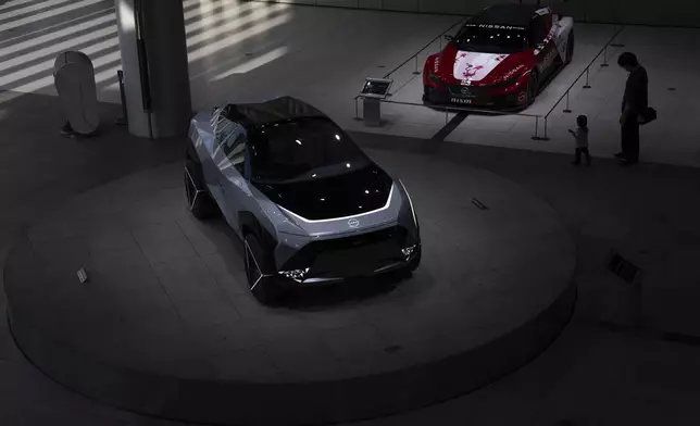 Visitors walk through a showroom at Nissan headquarters in Yokohama, Tuesday, May 13, 2025. (AP Photo/Louise Delmotte)
