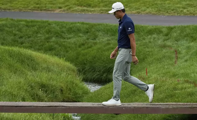 Collin Morikawa walks across a bridge on the second hole during the first round of the Memorial golf tournament, Thursday, May 29, 2025, in Dublin, Ohio. (AP Photo/Sue Ogrocki)