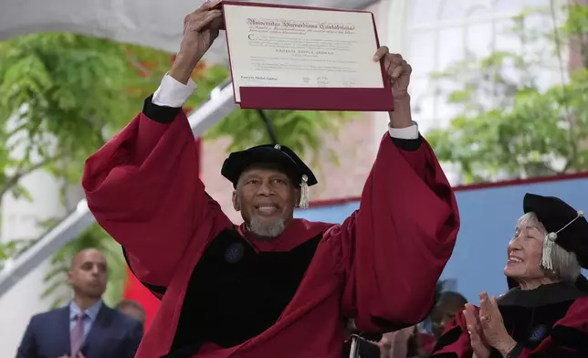 Basketball Hall of Famer and activist Kareem Abdul-Jabbar holds up an honorary degree during Harvard University's commencement ceremonies, Thursday, May 29, 2025 in Cambridge, Mass. (AP Photo/Charles Krupa)