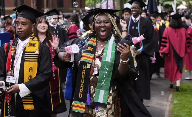 Students walk through Harvard Yard during commencement ceremonies at Harvard University, Thursday, May 29, 2025, in Cambridge, Mass. (AP Photo/Charles Krupa)