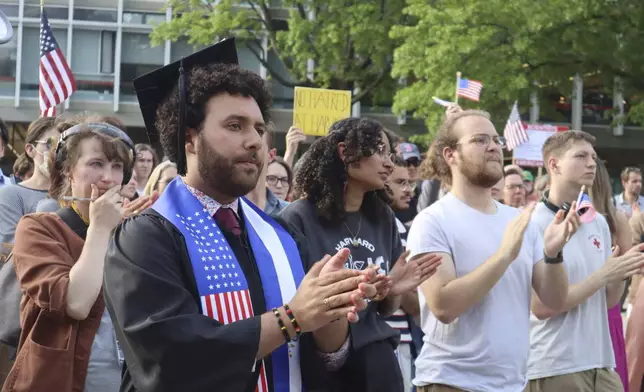 Harvard University graduating senior Victor Flores claps while listening to a fellow student speak at a protest against President Donald Trump's recent sanctions against Harvard in front of Science Center Plaza on Tuesday, May 27, 2025, in Cambridge, Mass. (AP Photo/Leah Willingham)