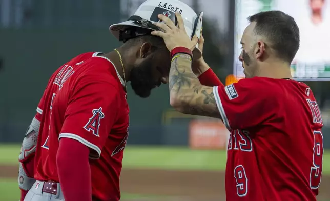 Los Angeles Angels' Zach Neto, right, celebrates with Jo Adell after he hit a home run during the fourth inning of a baseball game against the Athletics in West Sacramento, Calif., Wednesday, May 21, 2025. (AP Photo/Nic Coury)