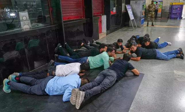 Civil defense members carry out a mock drill at a metro station to train civilians and security personnel to respond in case of attack, in New Delhi, India, Wednesday, May 7, 2025. (AP Photo/Manish Swarup)