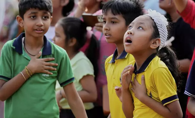 School students react during a mock drill to train civilians and security personnel to respond in case of attack, in Guwahati, India, Wednesday, May 7, 2025 amid rising fears of wider conflict following India's strikes in Pakistan. (AP Photo/Anupam Nath)