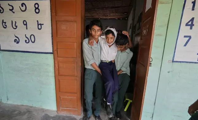 School students participate in a mock drill trained by civil defence members to respond in case of attack in Guwahati, India, Saturday, May 10, 2025 amid rising fears of wider conflict following India's strikes in Pakistan. (AP Photo/Anupam Nath)